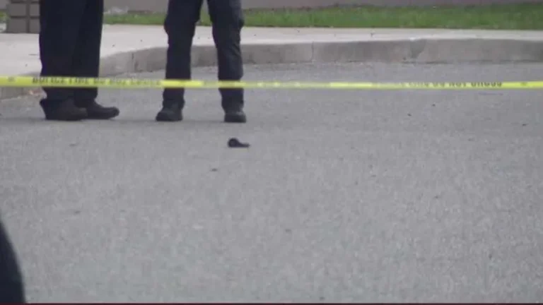 Police tape and patrol cars outside a police department building after a shooting